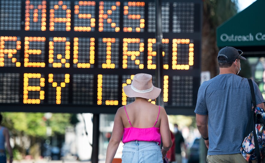 People walk along King Street last week in Charleston, S.C. South Carolina is one of many states in the U.S. struggling with a rising number of coronavirus cases.