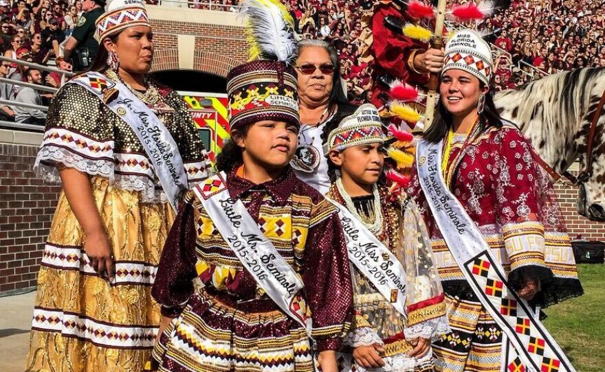 Reigning Seminole tribal royalty stand on the field at half time to crown the Homecoming King and Queen. (L to R) Skyla Osceola, Junior Miss Florida Seminole; Gregory James ll, Little Mr. Seminole; Victoria Benard, Little Miss Seminole; Wanda Bowers, director of the Miss Florida Seminole Princess Pageant; and Destiny Nunez, Miss Florida Seminole.