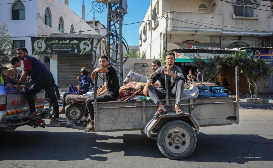 Palestinians on a car trailer flee with their belongings from Gaza City to southern Gaza after being told to leave their homes in the north by the Israeli military, Oct. 13, 2023.