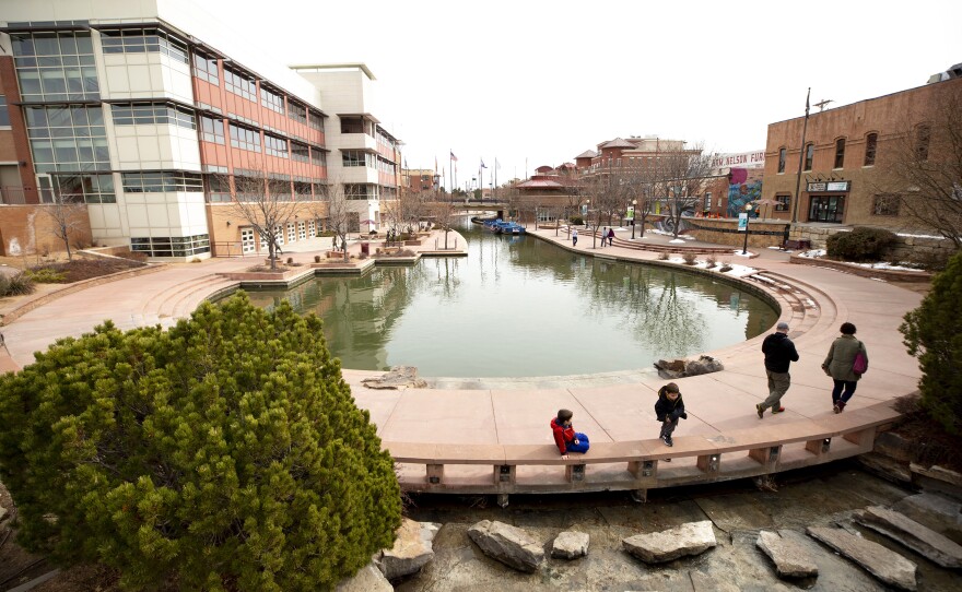 People walk by the Historic Arkansas Riverwalk in Pueblo, Colo. The area around Pueblo has strong ties to organized labor is now working to diversify its economy as steel jobs decline.