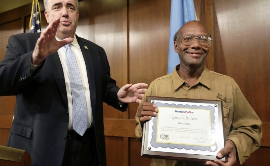 Glen James holds a special citation while facing reporters with Boston Police Commissioner Edward Davis, left, during a news conference at police headquarters on Sept. 16.