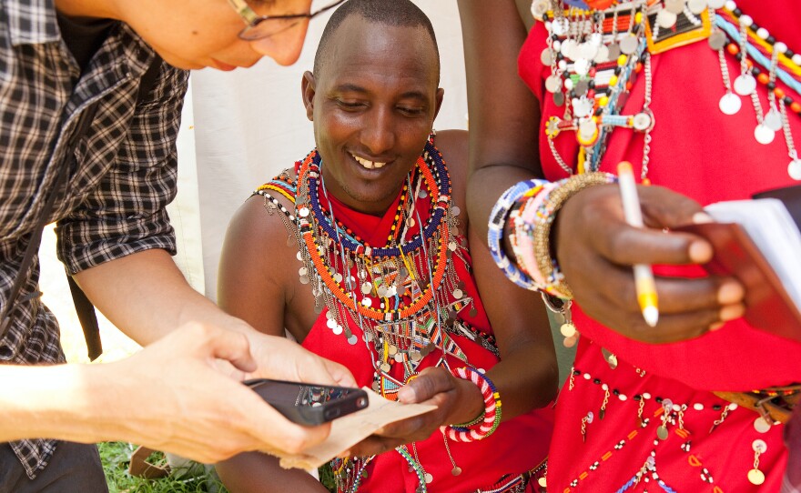 Philip Kisaikae and another Maasai warrior swap email addresses with Juan Carlos Vera, who attended this summer's Smithsonian Folklife Festival.