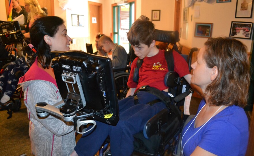 Speech-language pathologists Jill Tullman (left) and Mendi Carroll (right) work with Bryce Vernon at Talking with Technology Camp in Empire, Colo., on July 25.