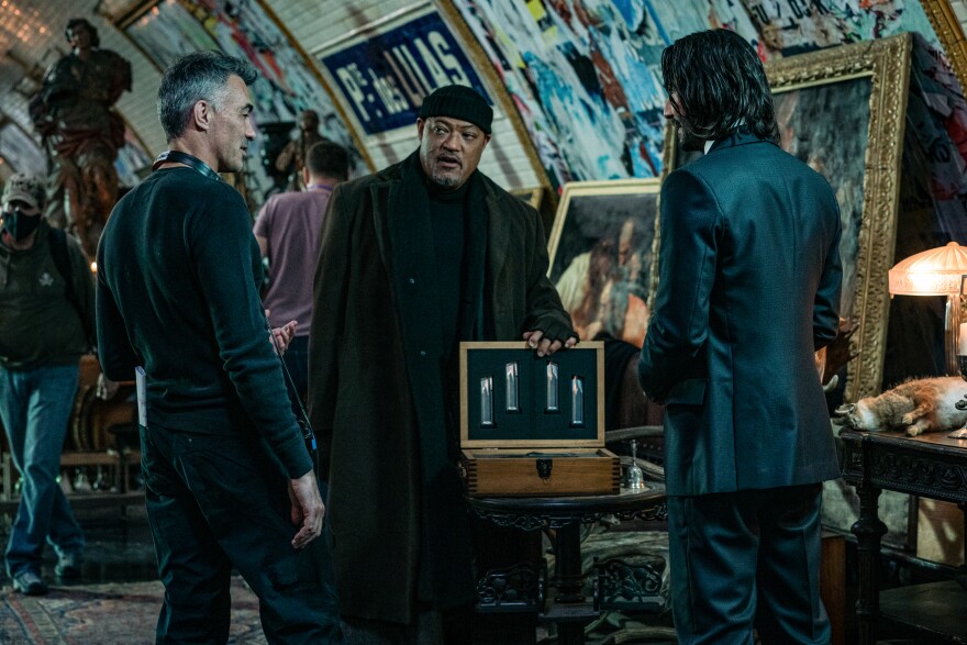 Director Chad Stahelski on the set of "John Wick 4" with actors Laurence Fishburne as Bowery King and Keanu Reeves as John Wick. Undated image.