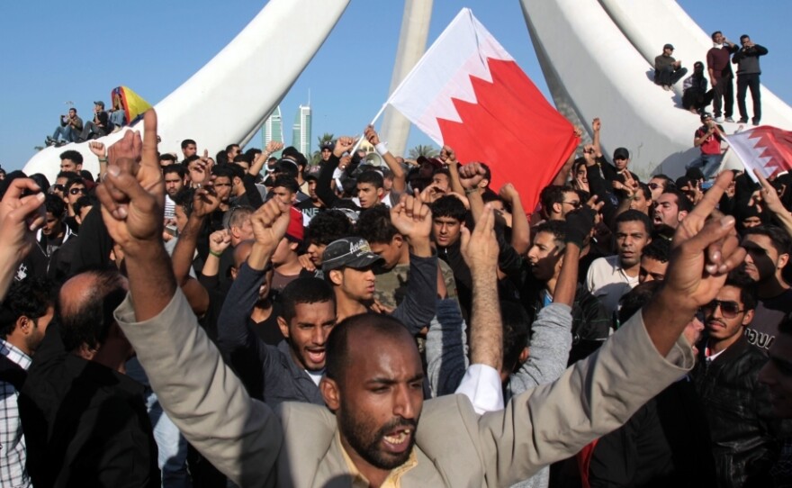 Demonstrators chant and wave Bahraini flags near the Pearl Monument on a main square in Manama, Bahrain, Tuesday. Thousands of protesters poured into the square in Bahrain's capital in an Egypt-style rebellion that sharply escalated pressure on authorities as the Arab push for change gripped the Gulf for the first time.