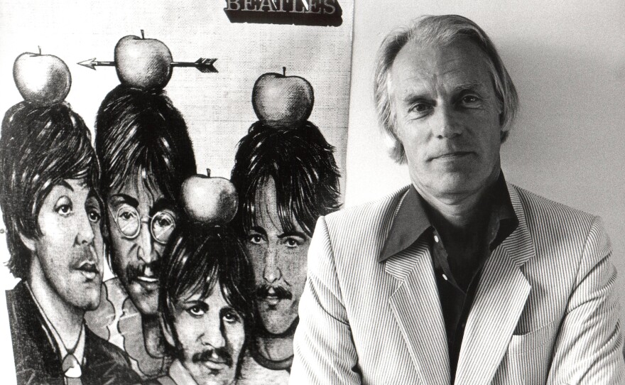 Martin stands with poster of Beatles in 1984. In a 2011 BBC interview, Martin said, "They had this wonderful charisma. They made you feel good to be with them. And I thought their music was rubbish." Martin signed The Beatles anyway, and came to love their songs.