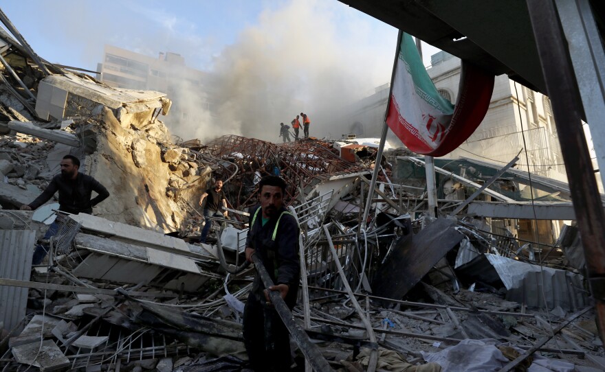 Emergency services work at a building hit by an air strike in Damascus, Syria, Monday.  Iran's consulate in Damascus was demolished and two Iranian generals were among those killed, Syrian and Iranian officials said.