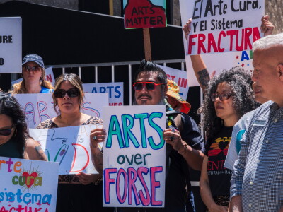 Protesters opposed to San Diego Mayor Todd Gloria's budget cuts to arts programs gather at San Diego's Civic Center Plaza before a City Council meeting on April 20, 2026.