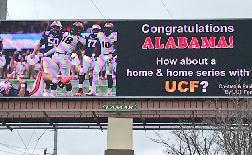 Perched on McFarland Boulevard in Tuscaloosa, home of the Alabama Crimson Tide, a new billboard bought by UCF fans lays down the gauntlet — which, it must be noted, is all but assured of not being picked up.