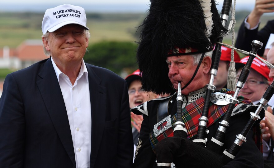 A bagpipe player wears traditional dress next to presumptive Republican presidential nominee Donald Trump at the Trump Turnberry Resort in Ayr, Scotland on Friday.