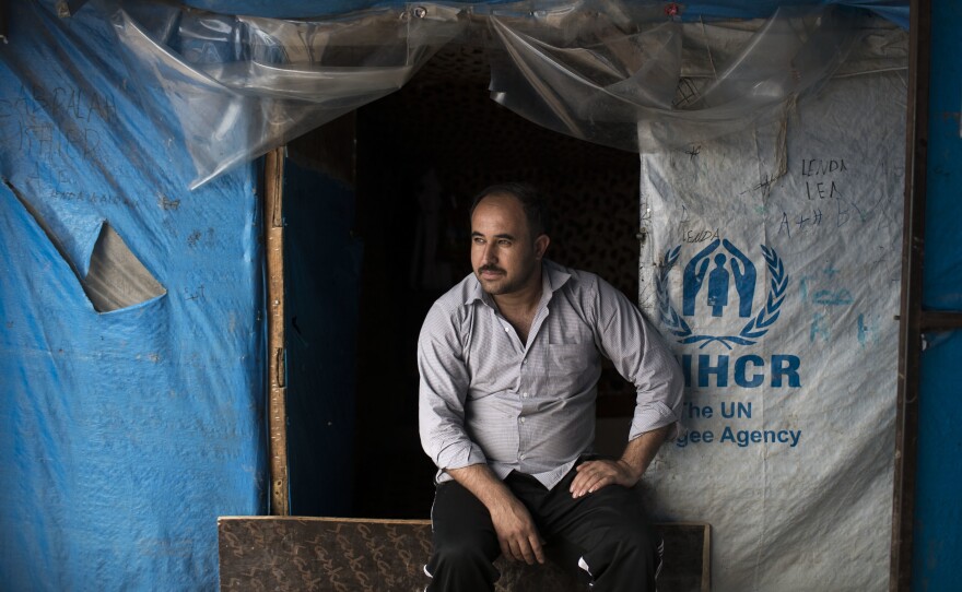 Suleiman Ibrahim Osman, from Syria, sits outside his tent in the Kawergosk refugee camp in northern Iraq in April. He's one of millions of people worldwide who have recently been forced out of their homes from war.