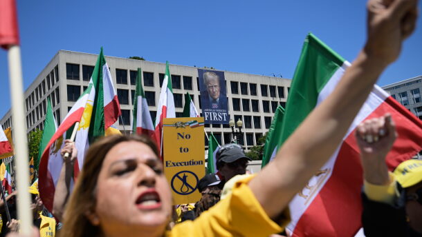 A banner of President Donald Trump hangs over Iranian Americans and their supporters as they march from the U.S. Capitol to the World War II Memorial during a rally Saturday, May 16, 2026, in Washington.