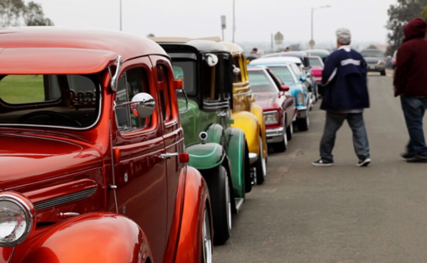 A street lined with parked customized lowrider cars.