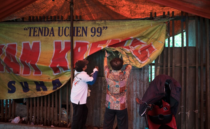 Alex Paulus and Yohannes Yudyharijono cover the opening to the church.