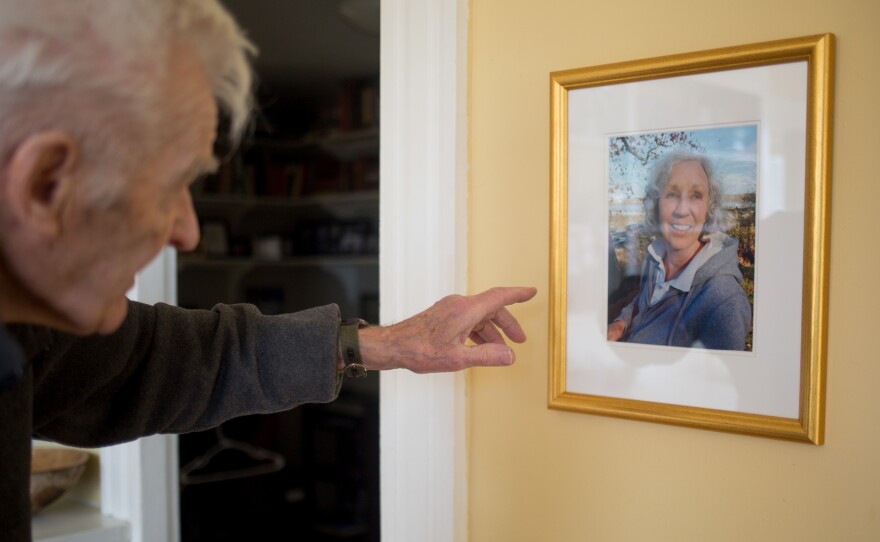 Jack Snow looks at a photo of his late wife, Lyn, on the wall of their home in Thomaston, Maine. Lyn Snow was bitten by a tick in late 2013 and died of Powassan, a tick-borne virus.