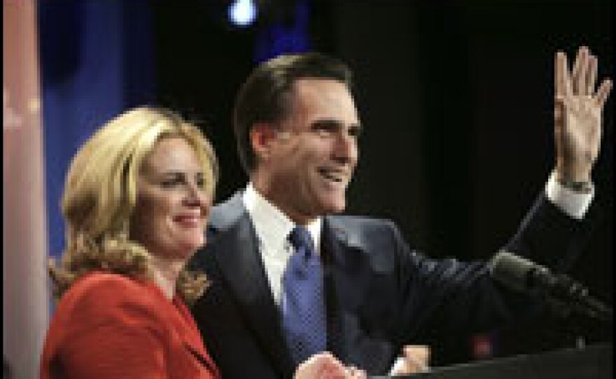 With his wife, Ann, by his side, Republican presidential hopeful Mitt Romney waves to supporters after speaking at his after-caucus party in Des Moines, Iowa, on Thursday. Romney placed second in the caucuses, finishing behind Mike Huckabee.