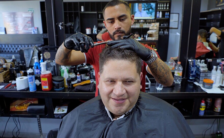 Host Jorge Meraz gets a haircut at a barber shop in Tijuana, Mexico. 