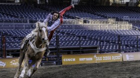 A woman performs stunts on a running horse at San Diego Rodeo inside Petco Park, Jan. 15, 2026.