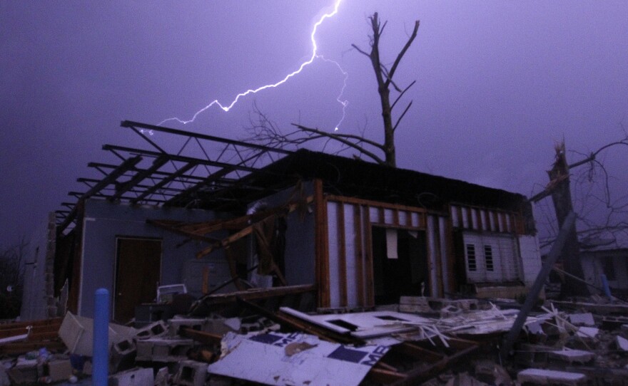 Lightning illuminates a house after a possible tornado touched down in Jefferson County, Ala., damaging several houses on Friday in Birmingham, Alabama.