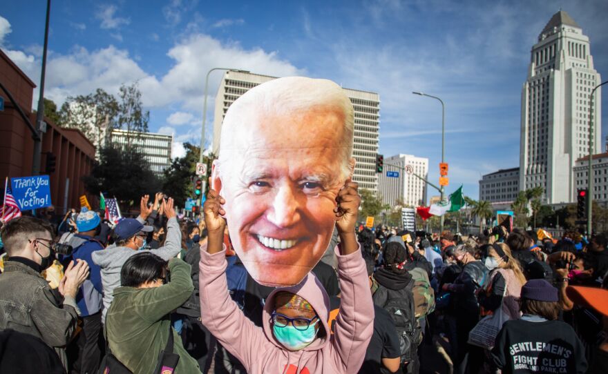 LOS ANGELES: A woman holds a Joe Biden mask as people march in Los Angeles celebrating after Joe Biden was declared the winner of the 2020 presidential election on November 7, 2020.