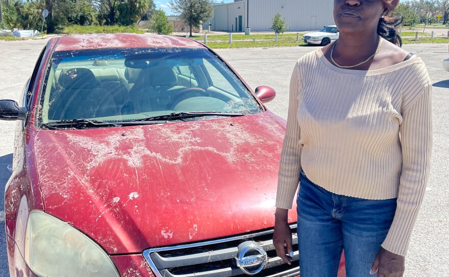 Virginia Hatcher Washington is seen next to the car she was sleeping in after Hurricane Ian tore through Arcadia, Fla. The Peace River was still flooding local highways several days after Ian.