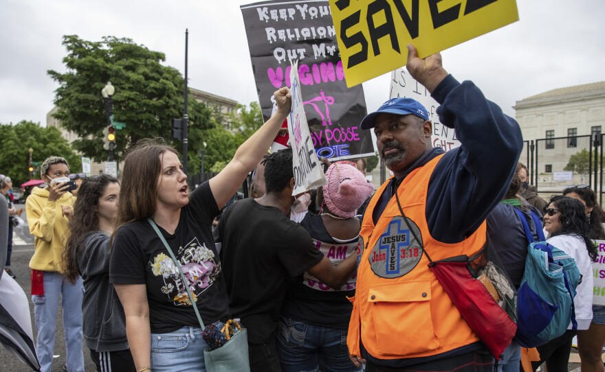 An abortion-rights protester, left, faces off against an anti-abortion protester in front of the U.S. Supreme Court in 2022.