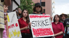 Debra Flores, an employee at Wendy's in downtown San Diego, stands amid protestors at a rally for an increase of the minimum wage, Aug. 29, 2013. 