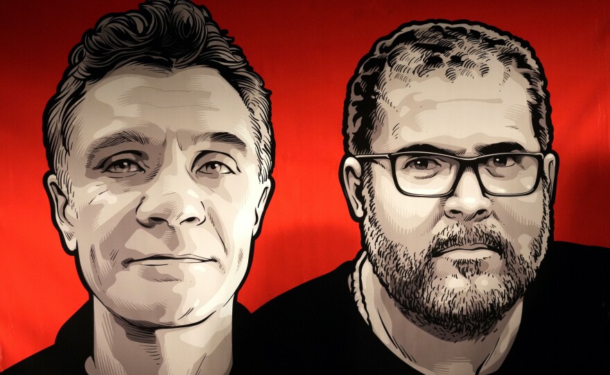 Images of British journalist Dom Phillips (left) and Indigenous affairs expert Bruno Pereira are seen on a sign presented by employees of Brazil's national Indigenous agency, FUNAI, during a vigil in Brasilia, Brazil, on June 9.