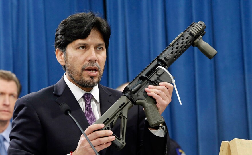 In this Jan. 13, 2014 file photo, former California State Sen. Kevin de Leon, D-Los Angeles, displays a homemade fully automatic rifle, confiscated by the Department of Justice, at the Capitol in Sacramento, Calif.