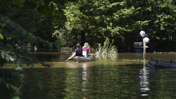 Residents paddle through a flooded neighborhood in a kayak in Indianapolis, Sunday, Aug. 16, 2026.