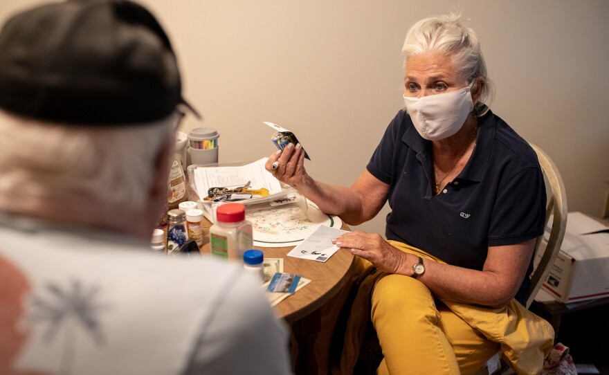 Kathleen McAuliffe, a home care worker for Catholic Charities in a Portland, Maine, suburb, helps client John Gardner with his weekly chores. McAuliffe shops for Gardner's groceries, cleans his home and runs errands for him during her weekly visit.
