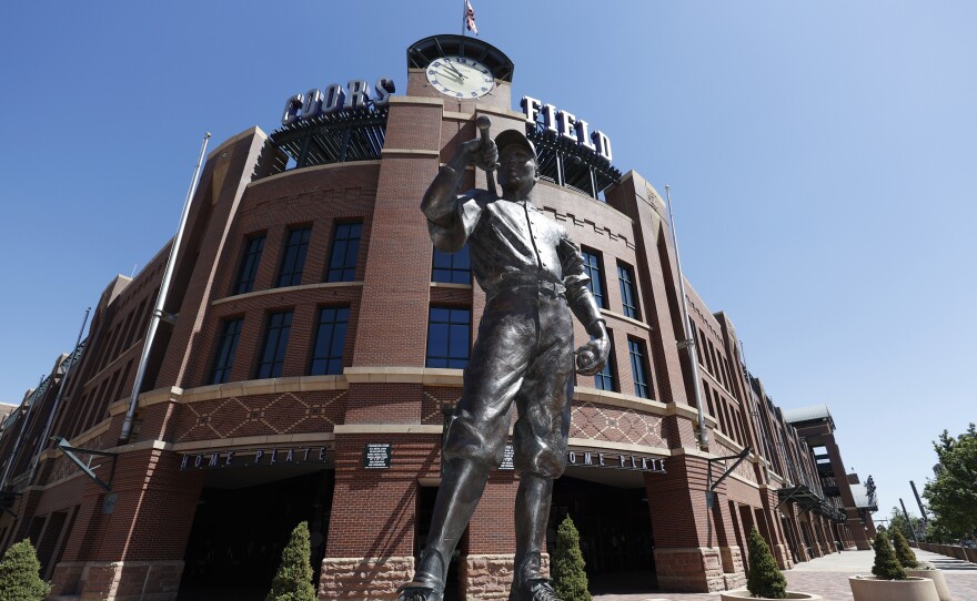 A bronze baseball player stands outside Coors Field in Denver, one of the stadiums idled during the coronavirus outbreak. The league and players association have agreed to  league is waiting for the players' union to respond to whether it will agree to play a shortened season beginning in late July.