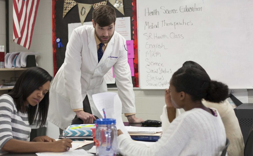 John Scarborough, a fourth-year pharmacy student at Lipscomb University, talks to high schoolers during a vocational career training class.