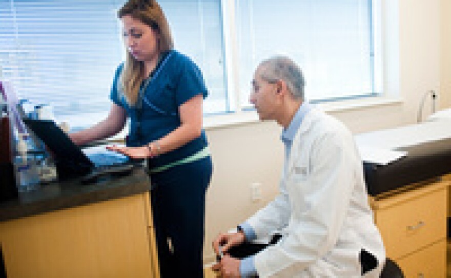 Medical scribe Connie Gayton keeps the electronic records allowing Orthodpedic surgeon Devesh Ramnath to focus on his patients.