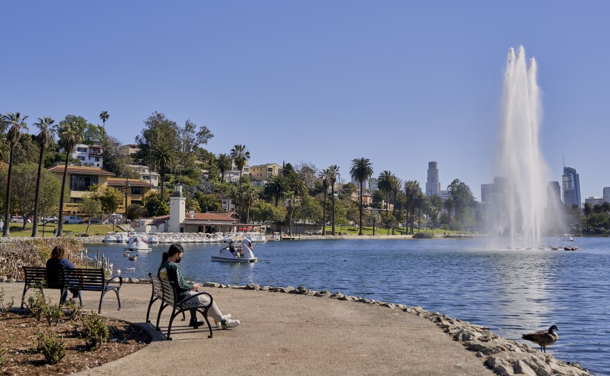 People sit on a bench at Echo Park Lake in March.