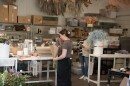 Native Poppy co-owner Natalie Gill is shown in the background and a worker putting together a floral arrangement is shown in the foreground of Native Poppy on March 21, 2024.