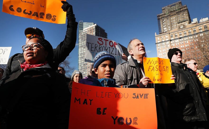 People attend an afternoon rally in New York City's Battery Park to protest President Donald Trump's new immigration policies.