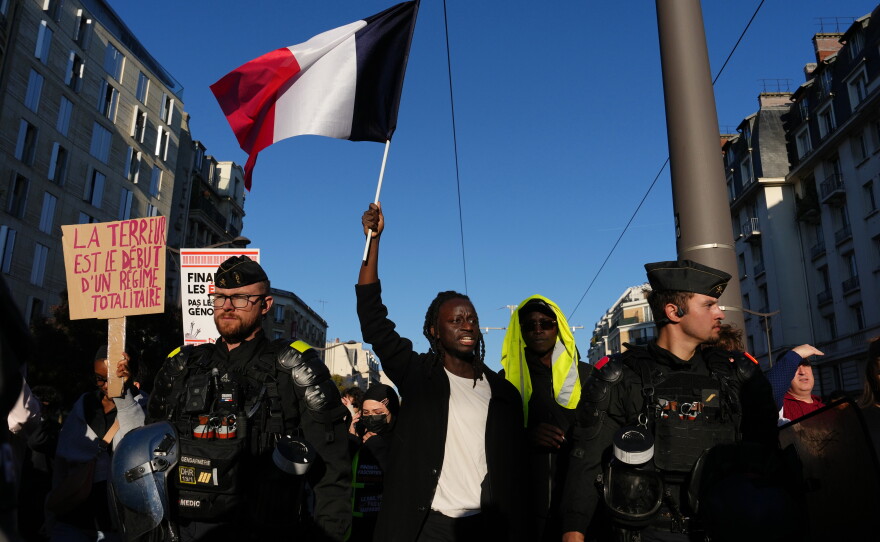 A demonstrator holds a French flag during a demonstration against rising living costs in Paris on Saturday.
