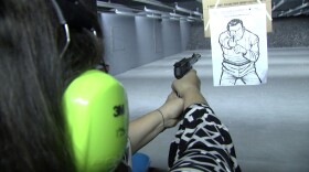 Monica Fay fires a gun at the Discount Gun Mart's shooting range, March 29, 2019.