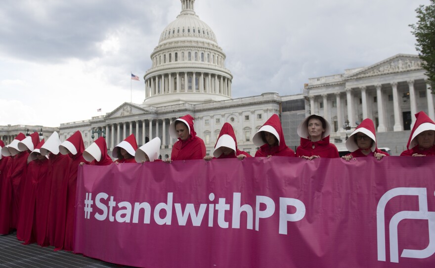 Supporters of Planned Parenthood dressed as characters from The Handmaid's Tale protest last June outside the Capitol against Senate Republicans' health care bill.