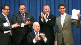 Calif. Gov. Jerry Brown signs the 2013-14 state budget, as Democratic legislative leaders and Budget Committee chairs watch, June 27, 2013. 