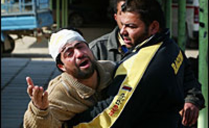 An injured Iraqi cries for his brother, who was killed in a bombing at a pet market in Baghdad on Feb. 1. Two female suicide bombers — who had been treated at the al-Rashad psychiatric hospital in the Iraqi capital — blew themselves up at a two separate markets that day.