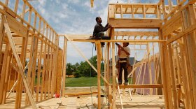 Construction workers frame a house in Louisville, Ky. New construction and existing home sales dropped in June.