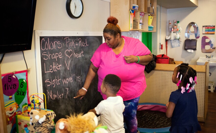 The program's assistant director, Tawanda Brand, works with students at the Little Explorers Learning Center in St. Louis on Jan. 29. After closing temporarily because of the coronavirus, the center re-opened in May for the children of essential workers. All staff members now wear masks.