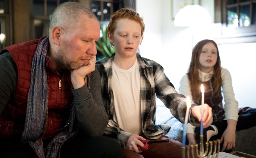 Carl Luepker, his son Liam, 12, and daughter Lucia, 11, light the menorah during Hanukkah in their home in Minneapolis, Minn. Carl and Liam both have a degenerative nerve disorder called dystonia.