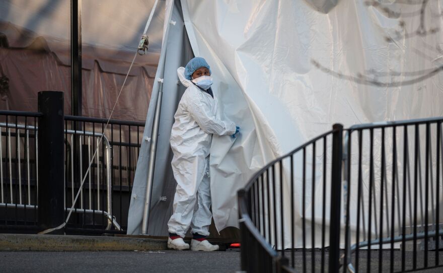 A medical worker at Elmhurst Hospital opens a tent at the COVID-19 testing site in the Queens borough of New York City.