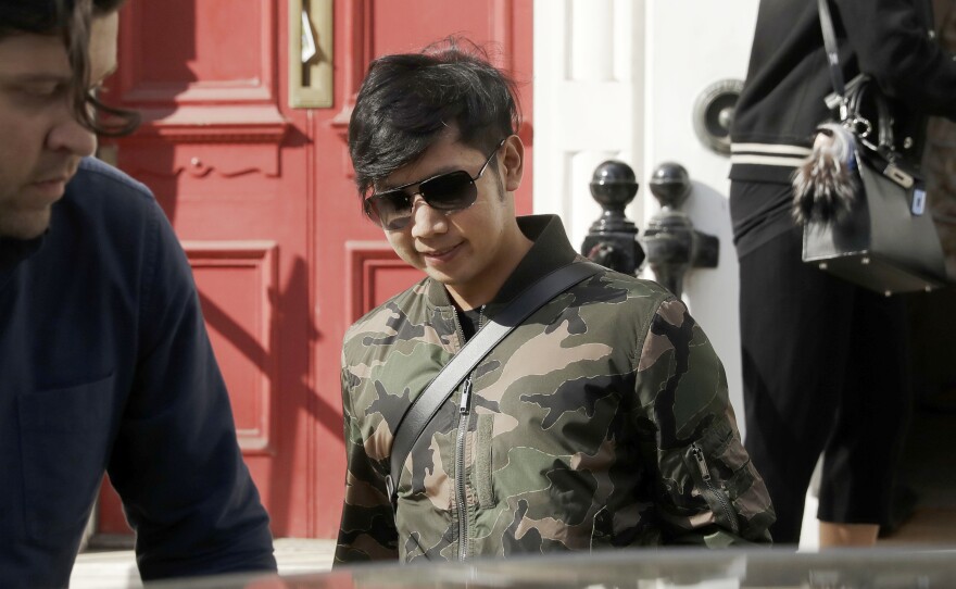 Vorayuth "Boss" Yoovidhya, whose grandfather invented Red Bull, walks to a car in London in April. Vorayuth has spent years dodging criminal charges over the death of a Thai policeman. On Monday, Interpol issued an international request for his arrest.