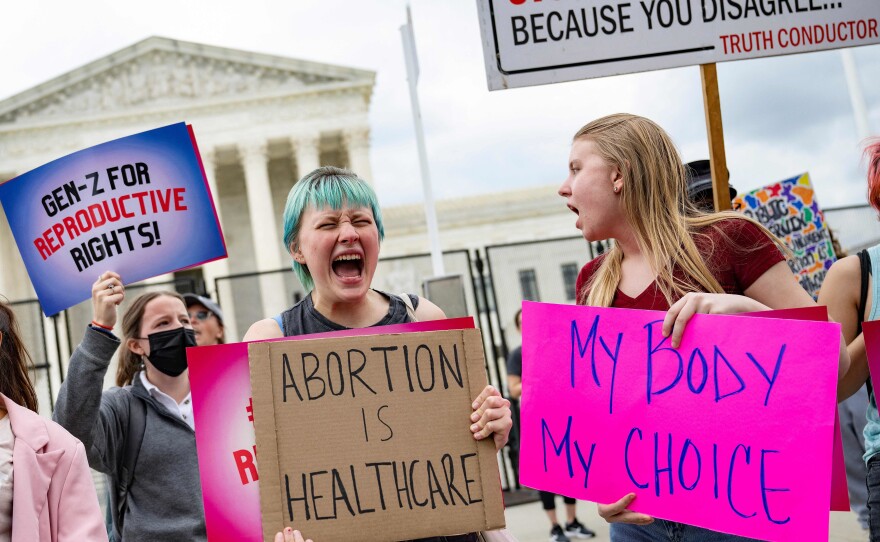 Young people who support access to abortion chant in front of un-scalable fence that stands around the US Supreme Court in Washington, DC, on May 5, 2022.