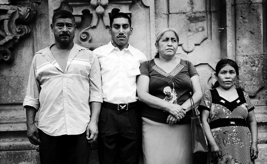 "Family Portrait After Church." Don Bernabe, left, and Dona Delfina, third from left, are the parents of missing Mexican student Adan Abrajan de la Cruz. They're posing with their godson, Marcos, and his mother, Dona Rosa.