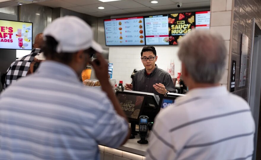 Lawrence Cheng, whose family owns seven Wendy's locations south of Los Angeles, takes orders from customers at his Wendy's restaurant in Fountain Valley on June 20, 2024.